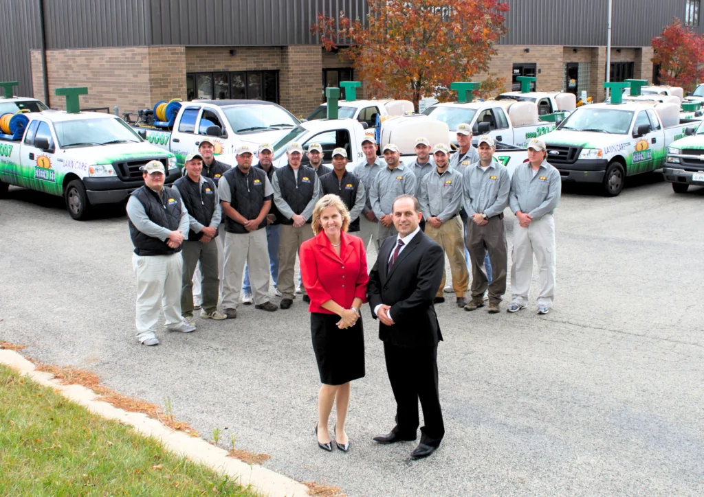 Company staff posing in front of service trucks, showcasing the Green T Carpet and Air Duct Cleaning professional team