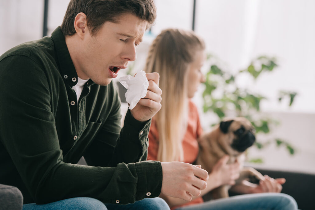 Person with allergies demonstrating the importance of air duct cleaning 