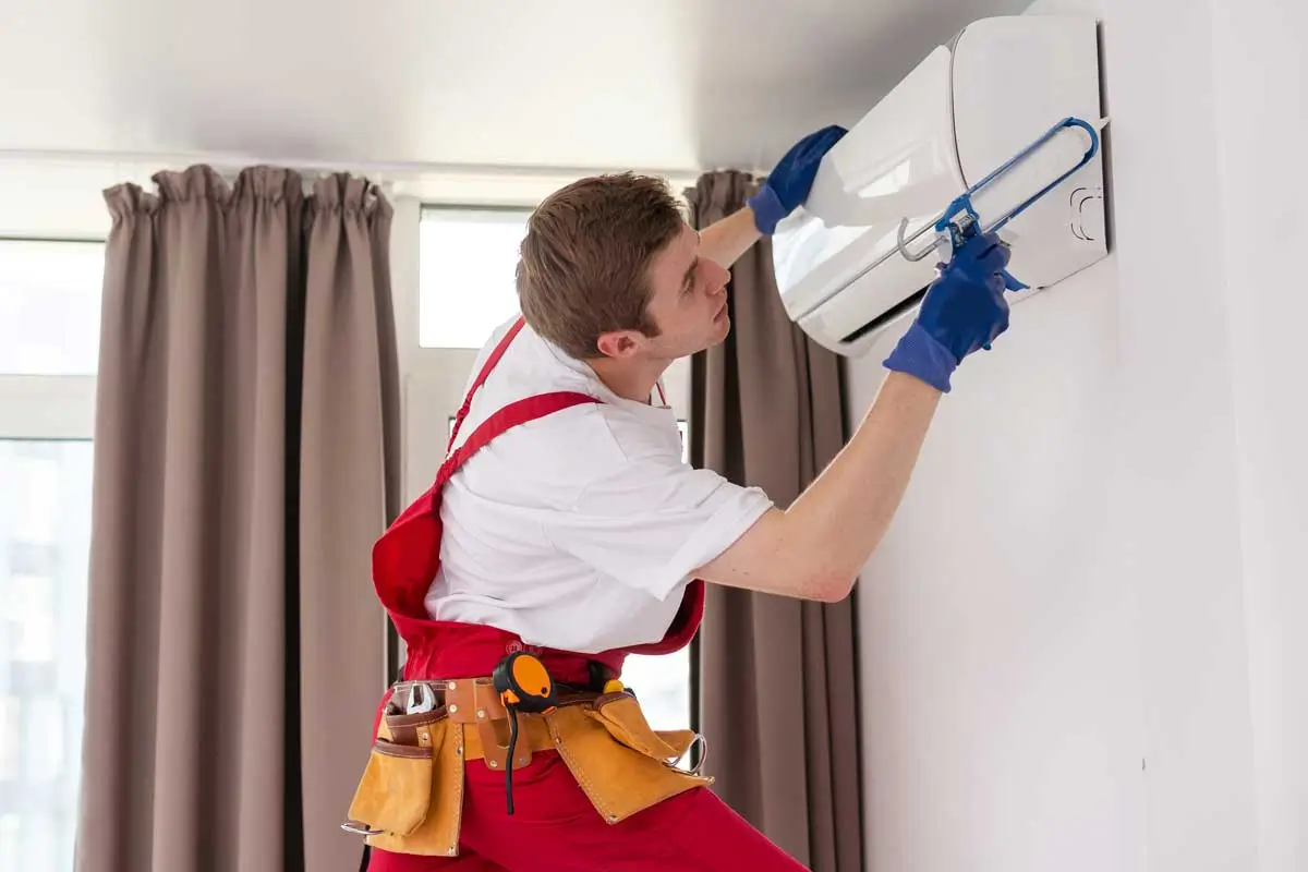 Service man cleaning, repairing and maintaining air duct system